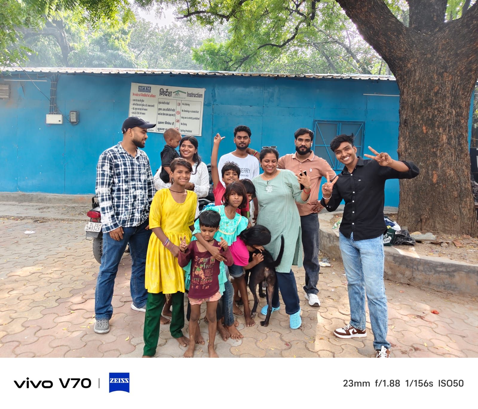 Volunteers and children posing for a group photo with a dog