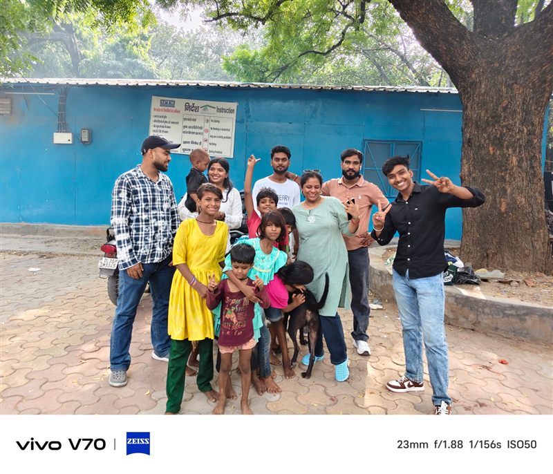 Volunteers and children posing for a group photo with a dog