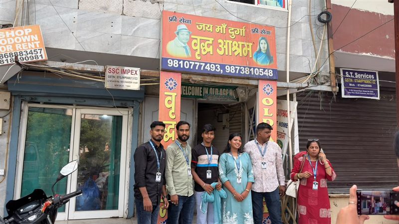 Six volunteers standing together outside a building entrance